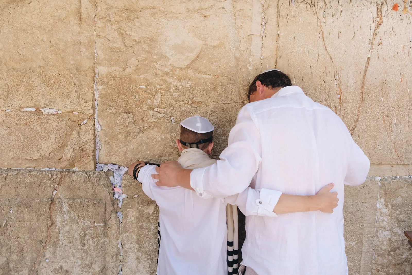 Zwei Menschen beten an der Klagemauer in Jerusalem